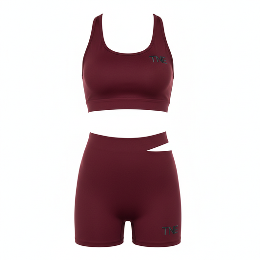 Burgundy matching sports bra and biker shorts set with TNE embroidered logo and cutout waist detail